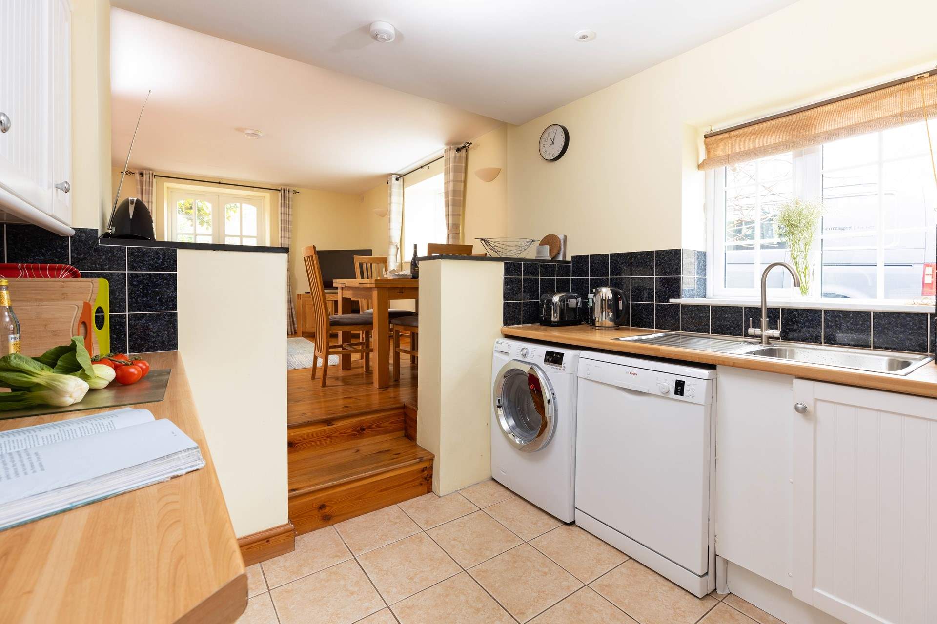 The kitchen is part of the open plan layout and accessed down the steps.