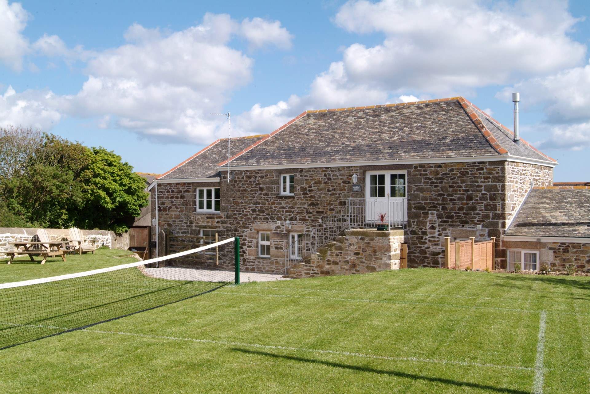 The grass tennis court in the garden (the net can be put up or down).