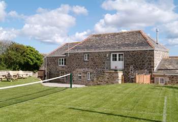 The grass tennis court in the garden (which can be put up or down).