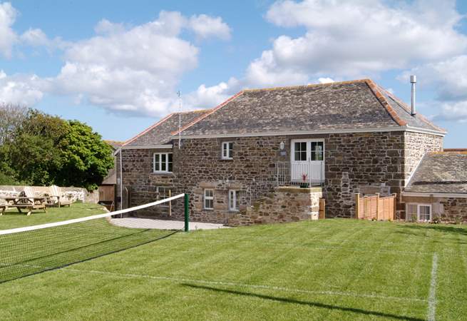 The grass tennis court in the garden (which can be put up or down).