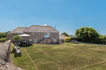 The grass tennis court in the garden which can be put up or down (tennis court available from Easter to October). The rattan furniture is removed from the end of Oct to end of Mar.