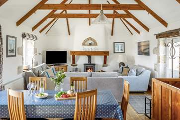 The open plan living area is light and bright and warmed by a wood-burner.