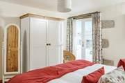 Bedroom 2 with a super-king bed is on the ground floor with French doors and an en suite shower-room.