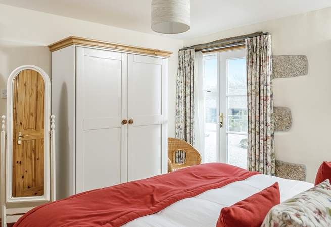 Bedroom 2 with a super king-size double bed is on the ground floor with French doors and an en-suite shower room.