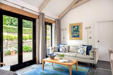 The open plan living room with large patio doors leading out to the garden