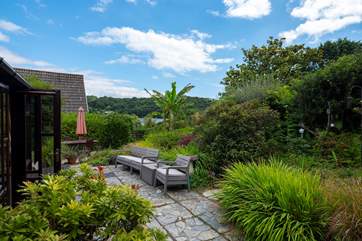 The paved garden outside the sun-room with glimpses of the river in the background.