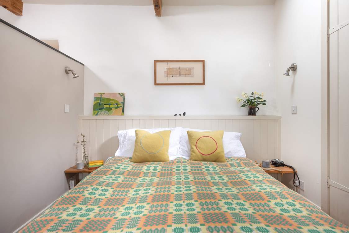 The comfy double bed is screened off from the main living area.