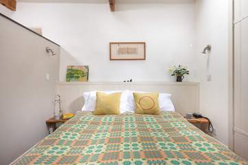 The comfy double bed is screened off from the main living area.