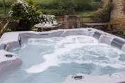 The hot tub is on the terrace at the back of the cottage.