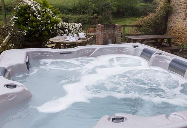 The hot tub is on the terrace at the back of the cottage.