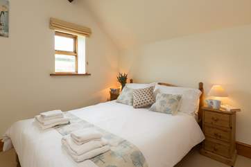 The room is bright and airy with views over the fields.