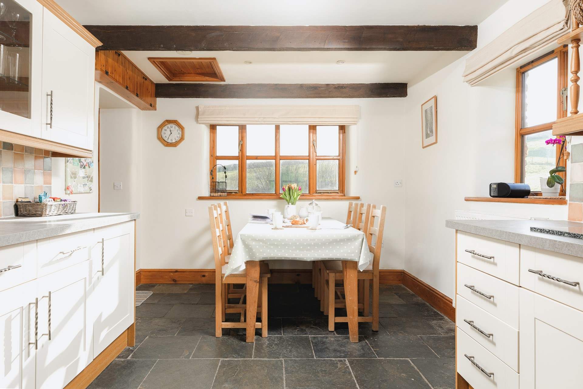 The farmhouse-style kitchen has flagstone floors and is equipped as a home-from-home.