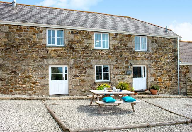 Pebble Cottage has a sitting-area in the courtyard with the Old Stable to the right of the picture.