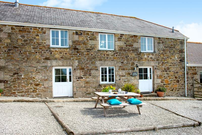 Pebble Cottage has a sitting-area in the courtyard with the Old Stable to the right of the picture.