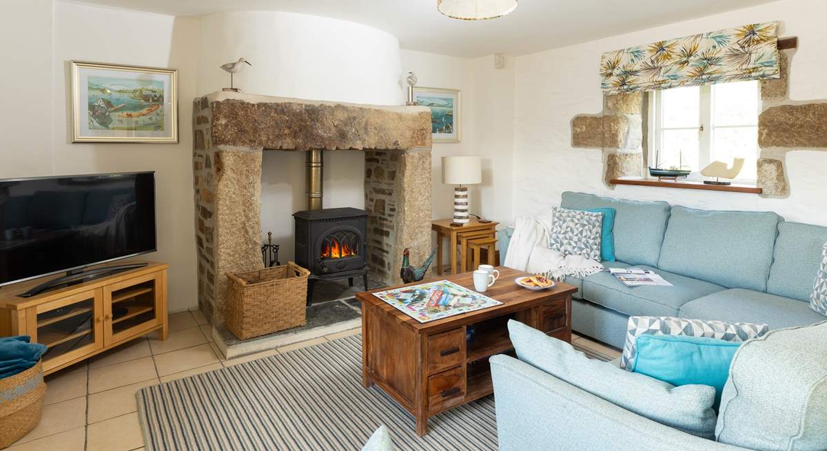 The lovely open plan living-room with comfy sofas around the wood-burner.