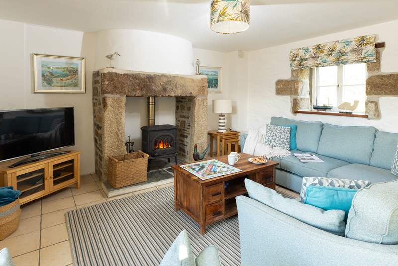 The lovely open plan living-room with comfy sofas around the wood-burner.