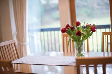 The dining-area has doors opening onto a balcony, overlooking the beautiful grounds.