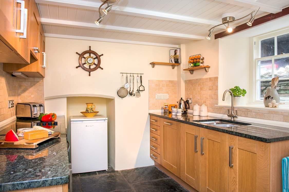 The cottage kitchen has original slate floors and granite worktops.