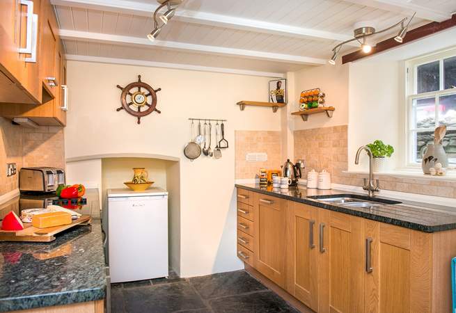 The cottage kitchen has original slate floors and granite worktops.