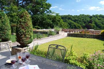 Looking down the pretty garden, separated from next door by a low wall and a low fence.