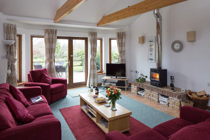 The sitting-room has French doors onto the rear terrace and the wood-burner makes it a great place to stay any time of year.