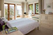 The master en-suite bedroom has French doors leading out onto the rear terrrace.