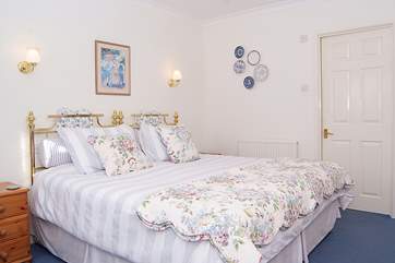 The bedroom is calm and luxurious with lovely bed linens and an en suite shower-room.