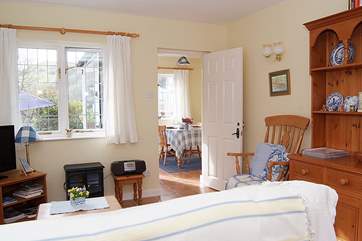 Looking across the living-area towards the dining-room/garden-room in this bright and cheerful cottage.