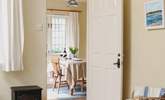 Looking across the living-area towards the dining-room/garden-room in this bright and cheerful cottage. - Thumbnail Image