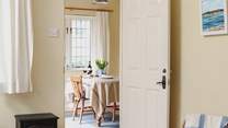Looking across the living-area towards the dining-room/garden-room in this bright and cheerful cottage.