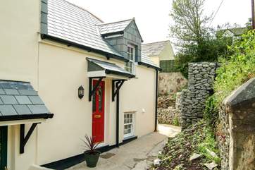A shallow flight of steps lead from the parking-area to Oyster Cottage, a modern end-of-terrace property much bigger in reality than it looks in the picture.
