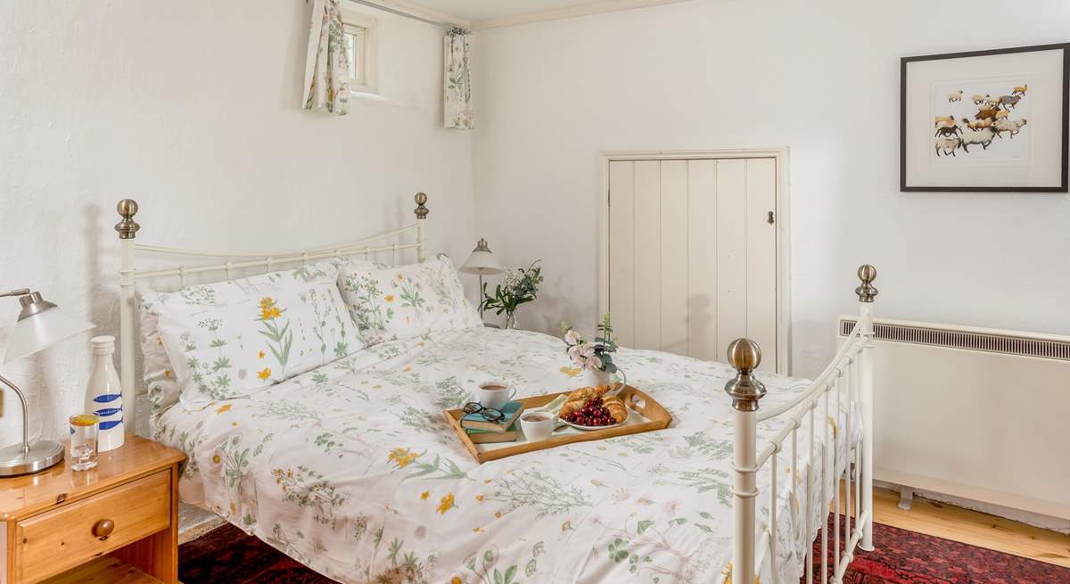 The master bedroom with pretty bedding linking to the outside (Bedroom 1).