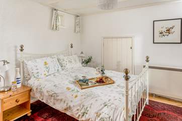 The master bedroom with pretty bedding linking to the outside (Bedroom 1).