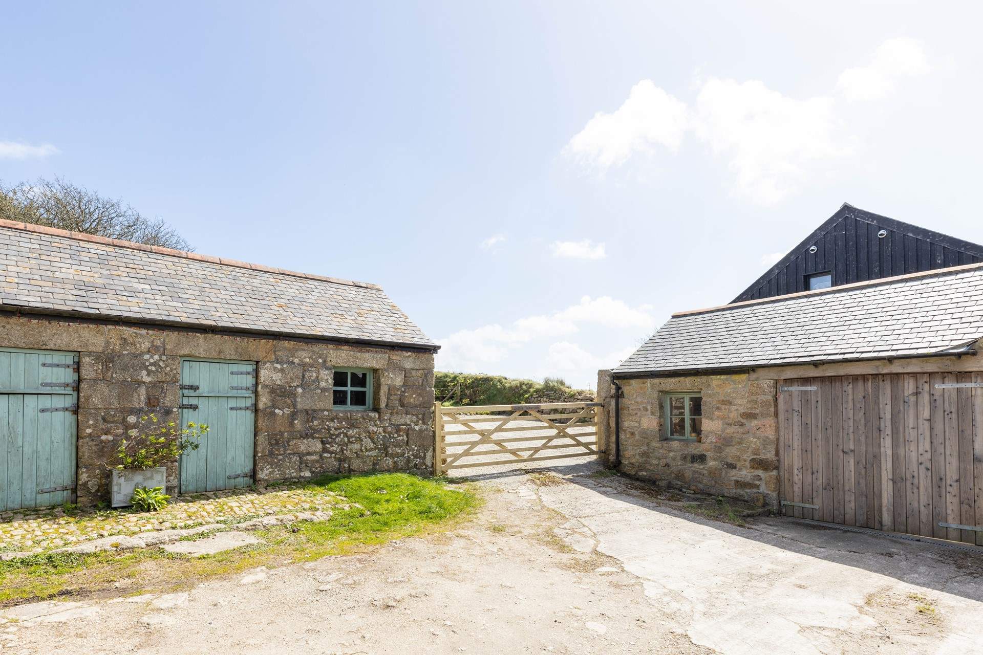 The entrance to the cottage parking with the laundry-room for Little Trebarvah in the single-storey barn on the left, the owners share access at the bottom of this drive. 