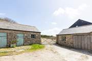 The entrance to the cottage parking with the laundry-room for Little Trebarvah in the single-storey barn on the left, the owners share access at the bottom of this drive.
