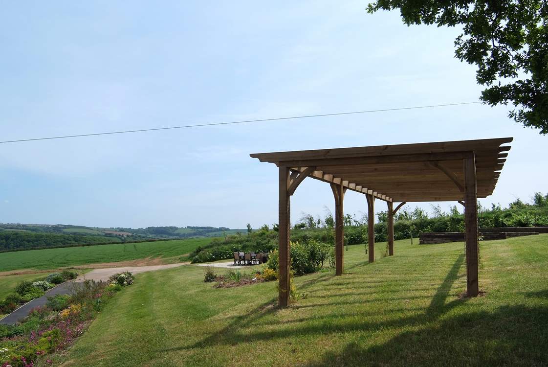 There is a pergola above the garden seating-area.