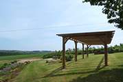 There is a pergola above the garden seating-area.