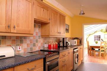 The well-equipped kitchen leads to the conservatory dining-room.