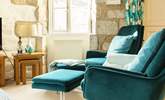 There are two modern comfy chairs with footstools for when you want to relax after dinner. - Thumbnail Image