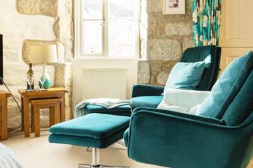 There are two modern comfy chairs with footstools when you want to relax after dinner.