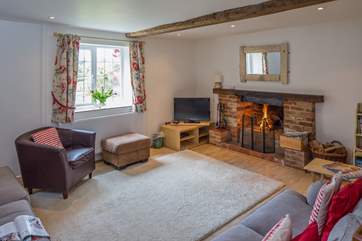The spacious sitting-room has a cosy open fire.