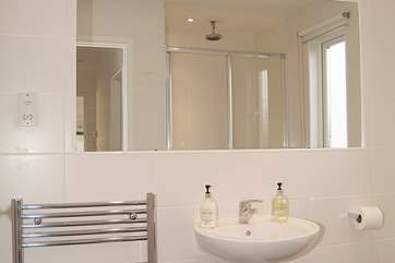 The stylish black and white family shower-room has a double shower cubicle and under-floor heating.
