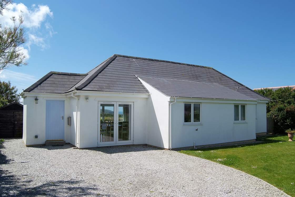 The enclosed front garden includes a large level lawn beside the parking-area.
