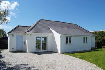 The enclosed front garden includes a large level lawn beside the parking-area.