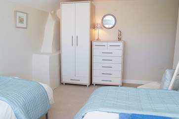 The twin bedroom is fitted with hanging and drawer space.