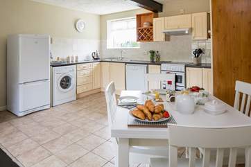 The bright kitchen with dining-area has plenty of space.