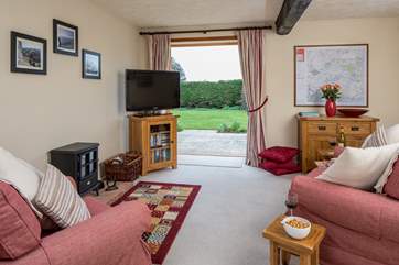 The spacious sitting-room has French windows which open onto a lovely private patio.
