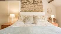 Paired back styling in the primary bedroom adds a touch of country-chic to your stay.