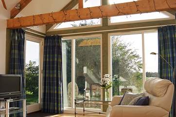 The glass apex wall lets sunshine flood into the cottage.