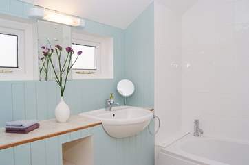The pretty bathroom has a fitted shower above the bath.